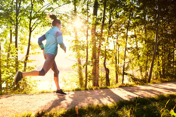 istock Woman running in park during sunny morning 1031874058