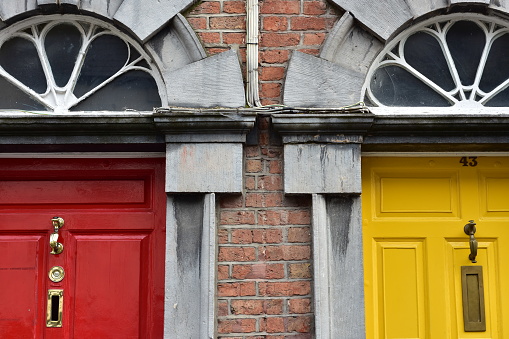 Typical wooden doors with colorful paint on English brick townhouse.