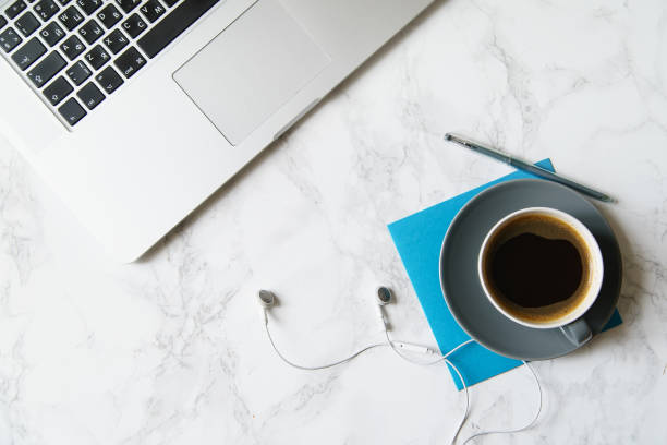 istock Workplace flatlay with laptop and coffee cup on marble table 1031876584