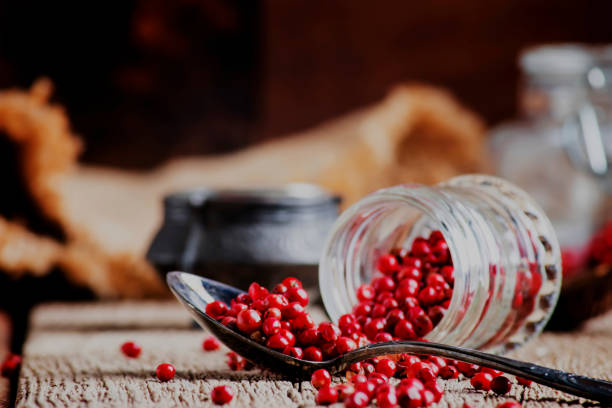 istock Pink pepper rose in a glass jar and spoon 1031877726