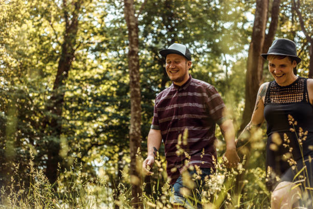 istock Smiling Young Couple Holding Hands and Walking Thru Meadow 1031886032