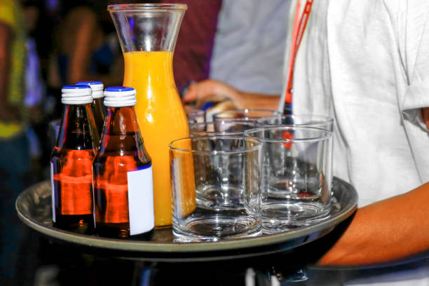Waiter serving orange juice and energy drink