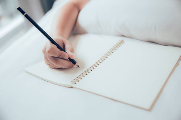 istock girl hand writing note blank book with pencil 1031889434