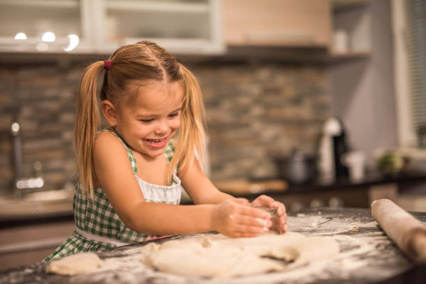 istock Cute little girl having fun while baking in the kitchen. 1031892894