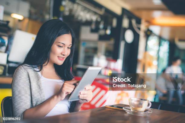 Schöne Attraktive Junge Asiatin Mit Smartphone Oder Handy Im Café Oder Kaffee Shop Am Morgen Stockfoto und mehr Bilder von Asien