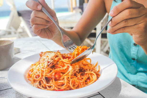 Young women eating king prawn linguine pasta
