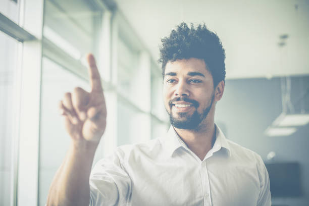 istock Close up.  African business man holding finger on touch screen. 1031904484