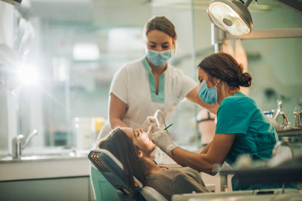 치과 의사 그리고 치과 드릴로 젊은 여자를 수행 그녀의 비서. - dental equipment dental drill dentist surgical mask 뉴스 사진 이미지