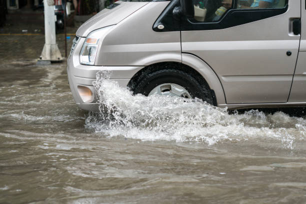 istock Car splashes through a large puddle on a flooded street 1031910146