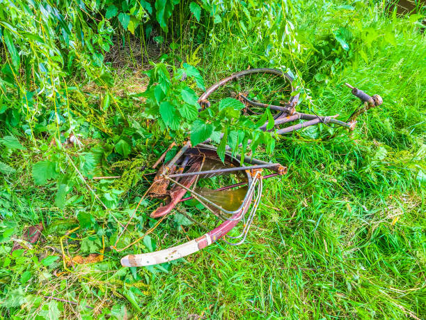 vieux sont effondrées vélos rouillés jetés dans le parc dans un champ d’herbe - whacked photos et images de collection