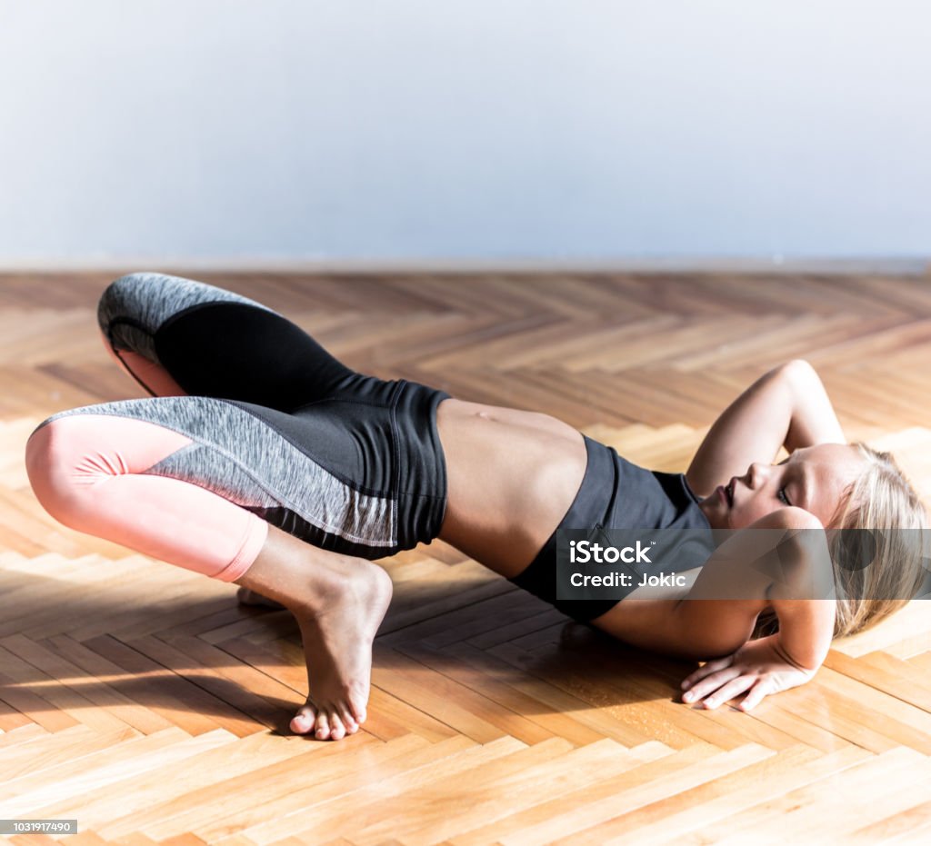 Little girl trying to do the bridge pose Teenage Girls Stock Photo