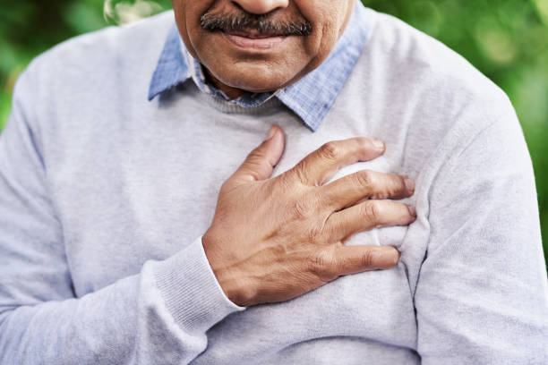 Your health risks increase with age Closeup shot of a mature man holding his chest in discomfort outdoors chest pain stock pictures, royalty-free photos & images