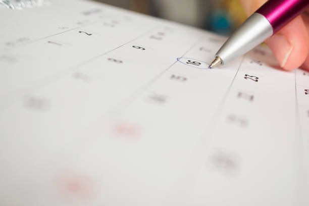 istock female hand holding pen circle mark on calendar page 1031928228