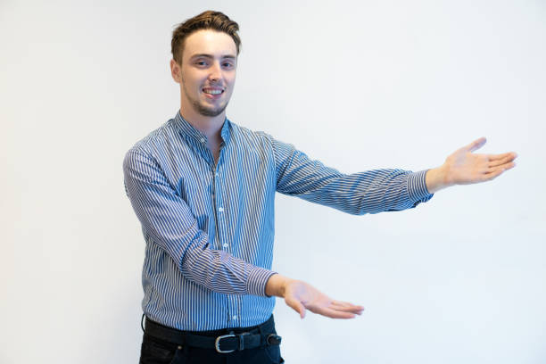 istock Cheerful male manager gesturing aside while presenting product 1031928440