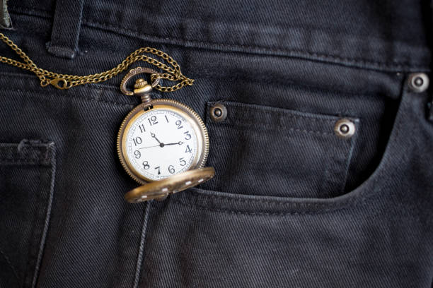 vintage pocket watch in pocket black jean stock photo