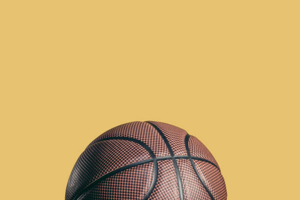 istock one rubber brown basketball ball isolated on yellow 1031931674
