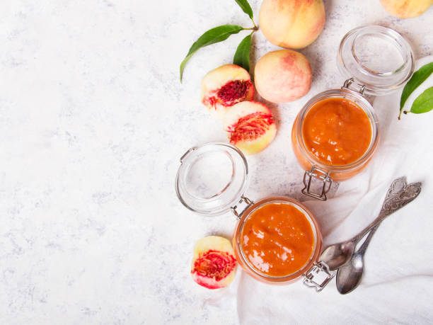 homemade peach jam with organic fruit. sweet preserves on a light background, copy space - preserves jar apricot marmalade imagens e fotografias de stock