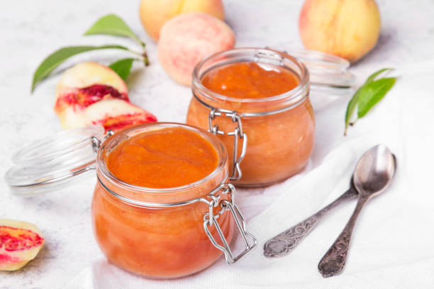 homemade peach jam with organic fruit. sweet preserves on a light background - preserves jar apricot marmalade imagens e fotografias de stock