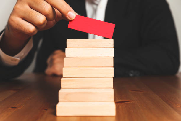 istock Hand arranging wood block stacking as step stair. Ladder career path 1031944378