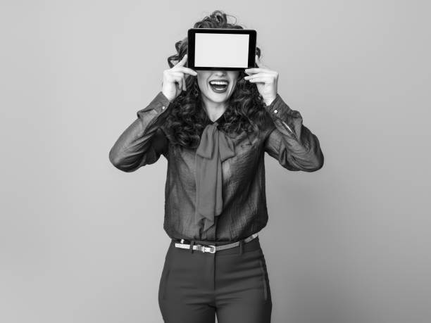 szczęśliwa stylowa kobieta ukrywająca się za tabletem pc pusty ekran - hiding internet multimedia people zdjęcia i obrazy z banku zdjęć