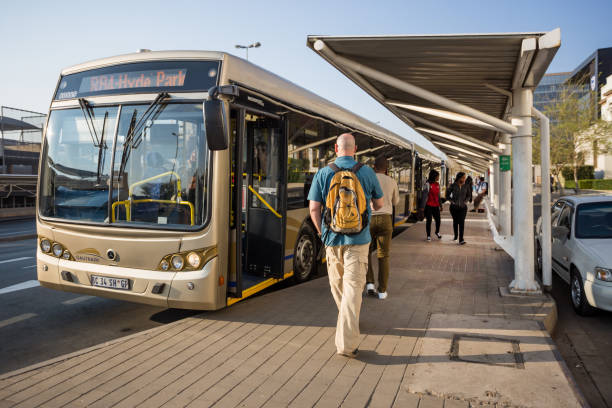 pasajeros a la espera de los autobuses de gautrain. - estación de autobús fotografías e imágenes de stock