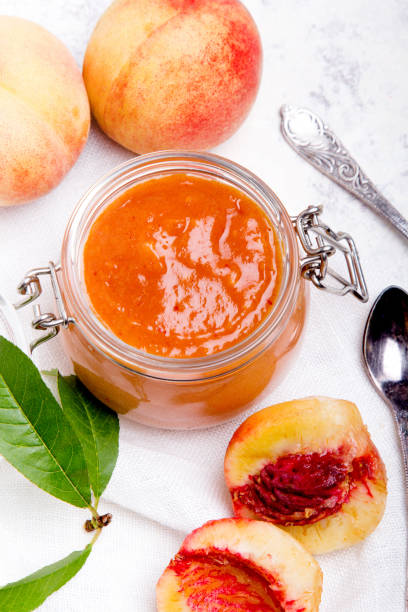 homemade peach jam with organic fruit. sweet preserves on a light background - preserves jar apricot marmalade imagens e fotografias de stock