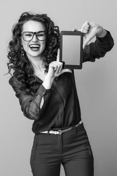 mujer feliz en el fondo mostrando tablet pc pantalla en blanco - 11681 fotografías e imágenes de stock