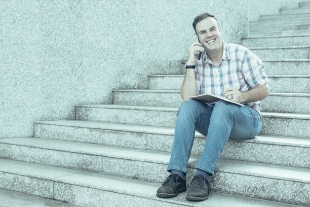 istock Positive freelance manager talking on phone outdoors 1031945414