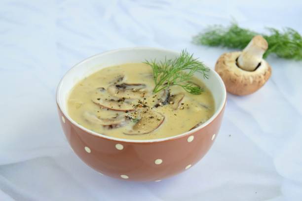 istock Mushroom cream soup with dill and black pepper on white background 1031949554