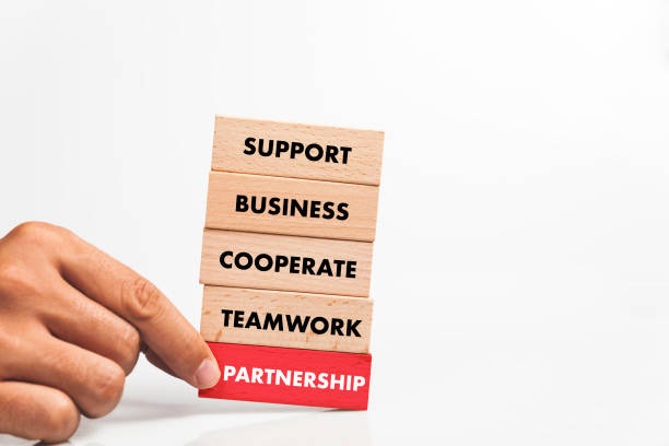 istock Businessman Building PARTNERSHIP concept with Wooden Blocks 1031949558