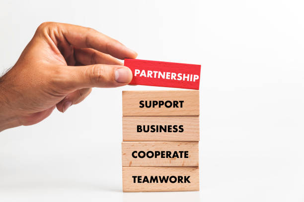 istock Businessman Building PARTNERSHIP concept with Wooden Blocks 1031949636