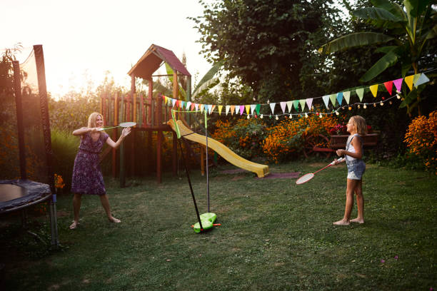 istock Mother and daughter playing badminton in backyard 1031956032