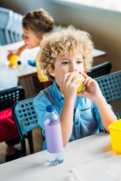istock adorable curly schoolboy taking lunch together at  school cafeteria 1031956144