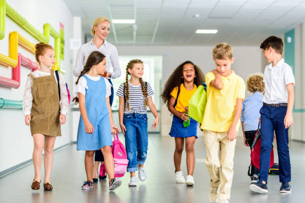 istock group of happy classmates walking by school corridor 1031956208