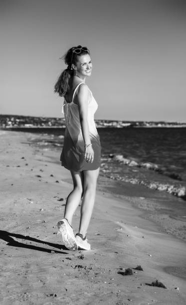 istock smiling fit woman on beach in evening walking 1031957150