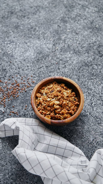 istock Granola in wooden bowl on gray background. Flatlay with copy space 1031960090