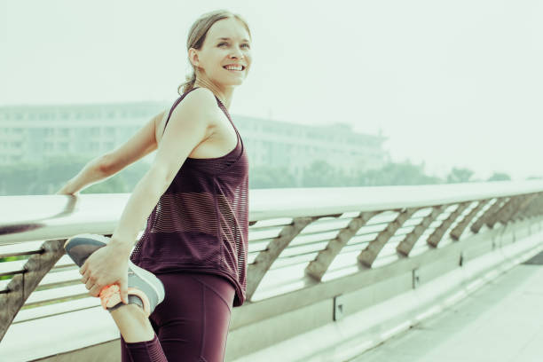 istock Happy Girl Holding and Stretching Leg on Bridge 1031960276