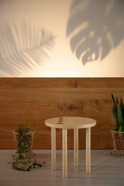 istock Simple table between plants on a wooden background and leaf shaped shadows. Real photo 1031968532
