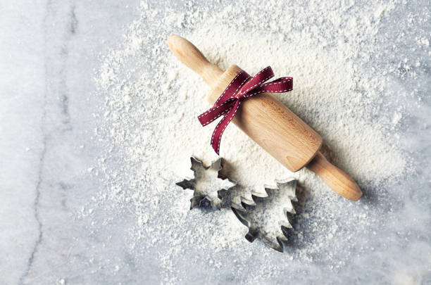 istock A floured marble work surface, cutters and a rolling pin with red ribbon. Christmas baking. Flatlay. Copy space 1031975976