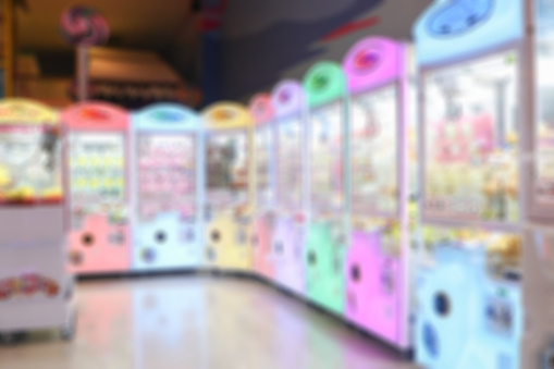 Blurred background of An arcade game or coin-op is a coin-operated entertainment machine typically installed in public businesses such as restaurants, bars and amusement arcades.