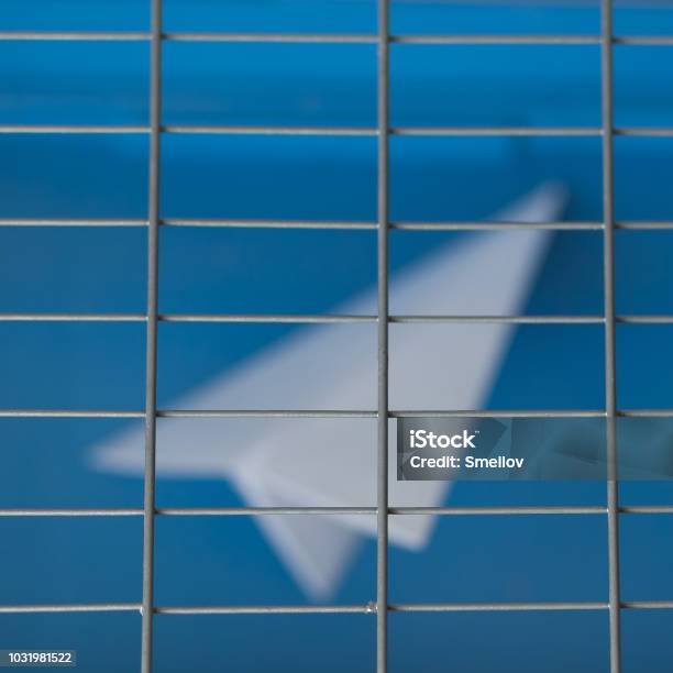 Russia Is Blocking Telegram Silhouette Of A Paper Plane Behind Bars On A Blue Background Stock Photo - Download Image Now
