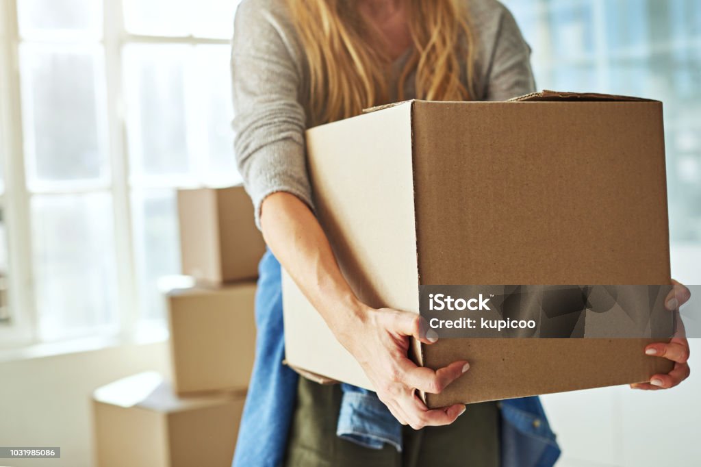Just one more box and I'm done Cropped shot of a young woman carrying boxes while moving into her new home Box - Container Stock Photo