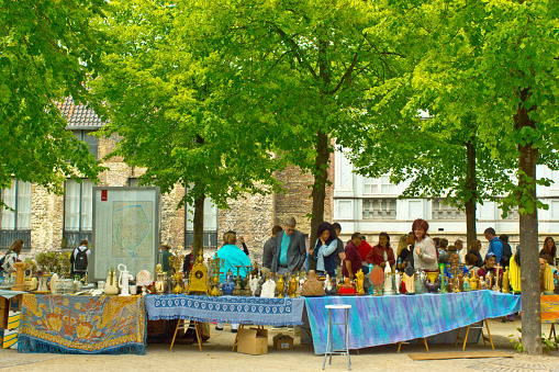 Shopping beside the canal with a street market and stalls and tourists looking at the antiques and collectibles on sale.