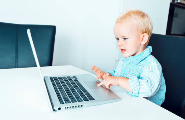 istock Happy boys uses laptop computer and smiles when looking at the screen 1031994826