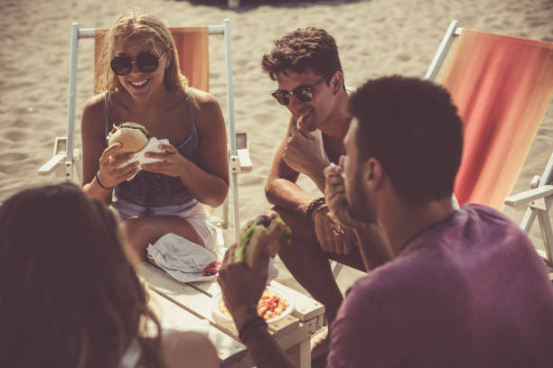 istock Friends eating fast food at the beach 1032012046