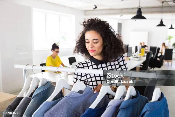 Fashion Stylist Looking At The Clothes On Rack Stock Photo - Download Image Now - Choosing, Fashion Stylist, Textile