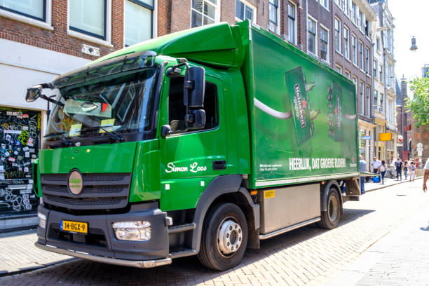 Heineken beer electric delivery truck bringing beer to bars in the narrow streets of the city center in Amsterdam Heineken beer electric delivery truck bringing beer to bars in the narrow streets of the city center in Amsterdam, the Netherlands. People are walking on the sidewalk. wellen stock pictures, royalty-free photos & images