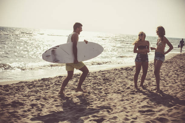 istock Young surfer passing by tourist girls 1032028274
