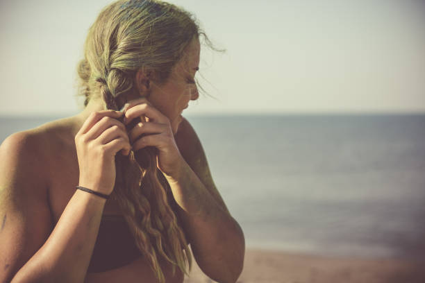portrait of young asian girl sitting on the stone near the sea