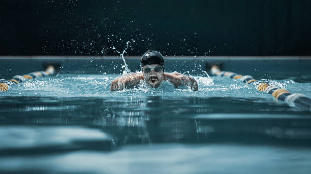 istock dynamic and fit swimmer in cap breathing performing the butterfly stroke 1032039236